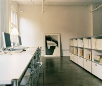 Vier Haller-Schreibtische als
Computer-Workstation,
parallel zu den raumtrennenden
USM Bücherregalen.